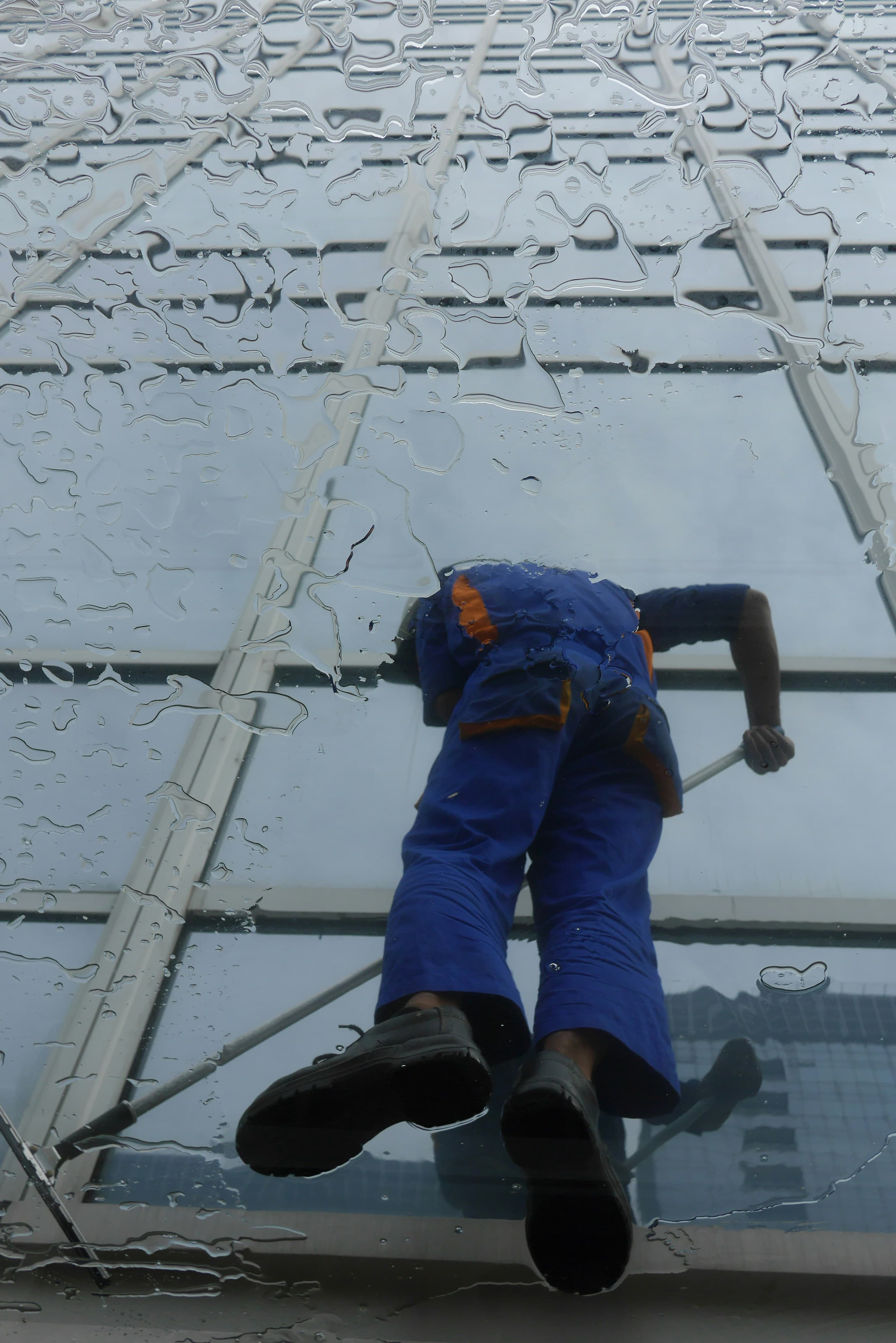 Fensterreiniger bei der professionellen Arbeit an einer Glasfassade