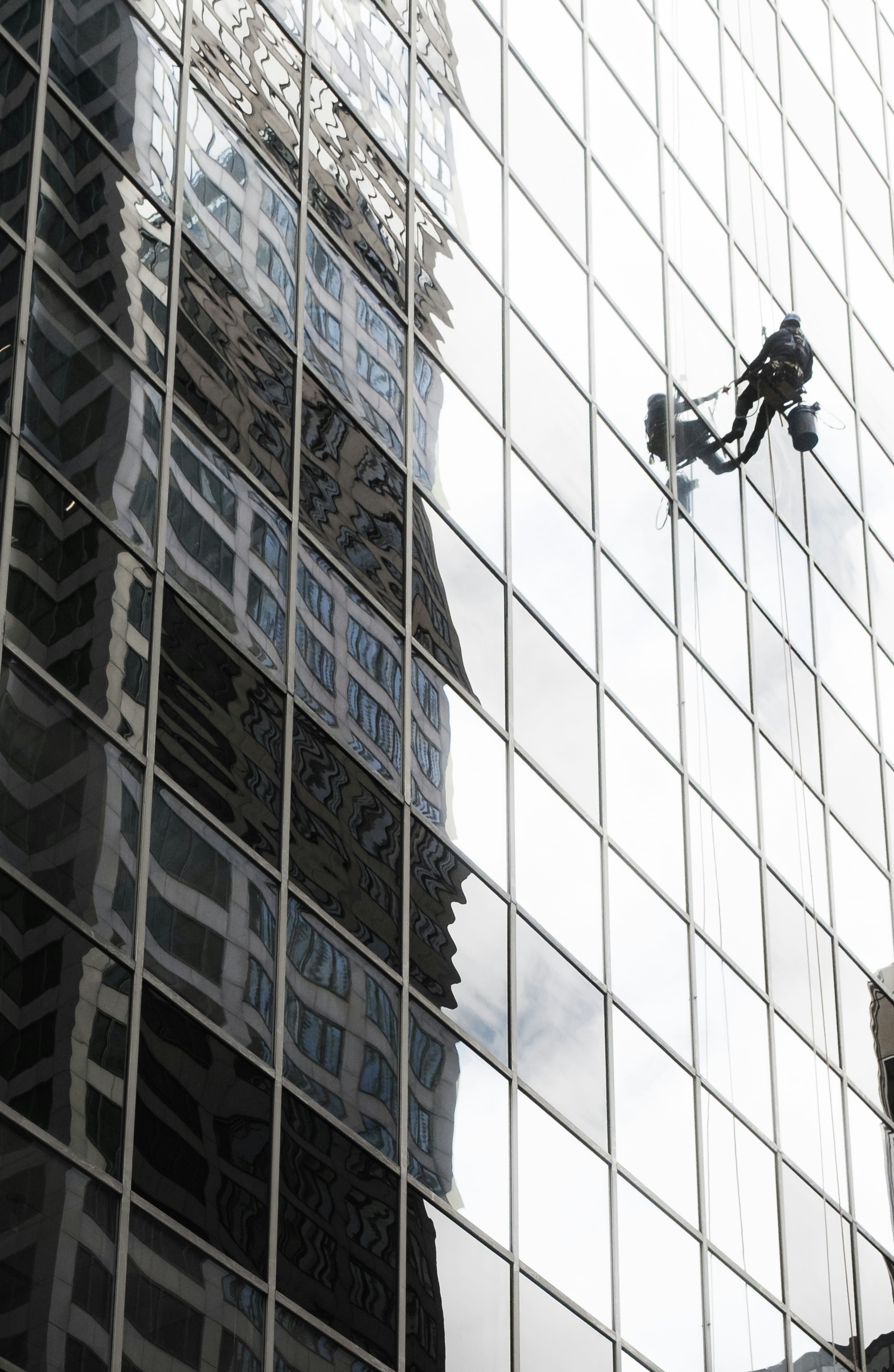 Fensterreiniger arbeitet an einer modernen Glas-Wolkenkratzerfassade